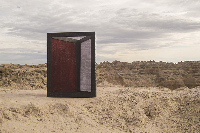 Gina Hunt, Mirroring  Theater scrim, Acrylic on PVC mesh, and polyester screen mesh stretched over three painted frames and attached with steel hinges 48 inches x 36 inches x 36 inches Installed at Badlands National Park, South Dakota, 2016