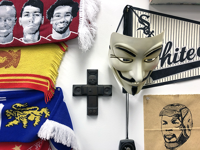 Football scarves, a cruciform, Sox pennant, silk screen print and Guy Fawkes mask from the Occupy movement.