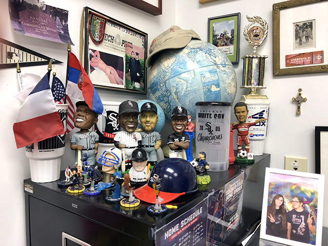 Chicago Fire (Cuauhtémoc Blanco) and White Sox (Paul Konerko, Minnie Miñoso, Frank Thomas) bobbleheads are surrounded by pictures from students, trinkets, and a globe.